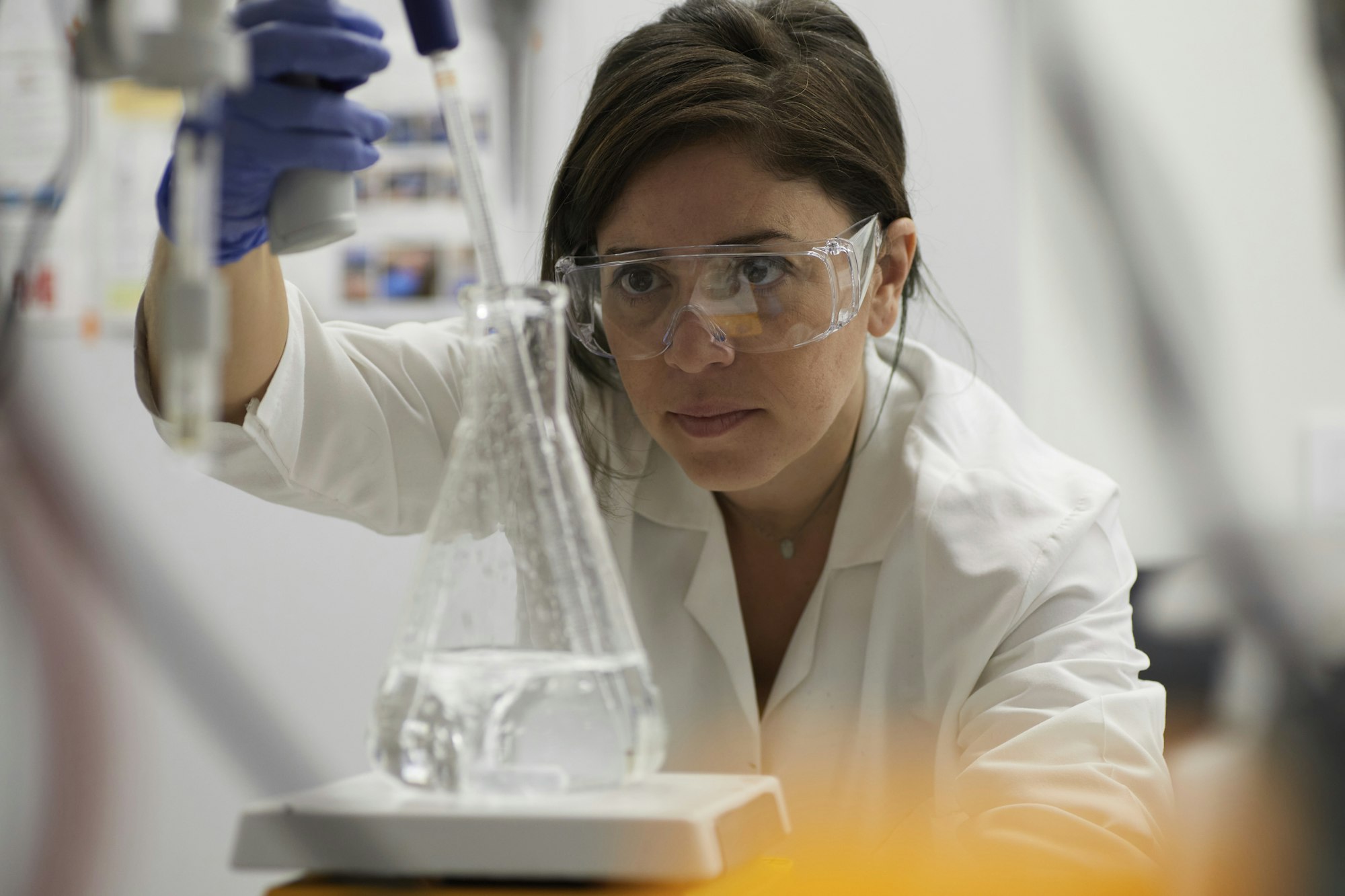 Attractive female scientist testing using beaker and peppet in labratory